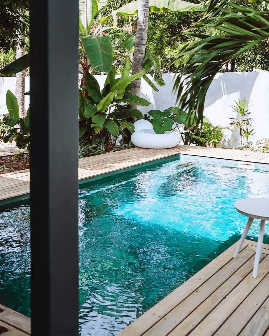 Piscine turquoise en pierre naturelle et deck en bois de la Villa Jélys, La Saline-les-Bains